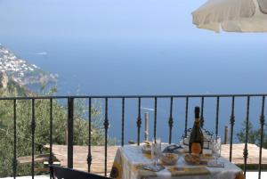 a table with a bottle of wine and food on a balcony at B&B La Selva Santa in Positano
