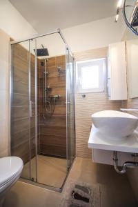 W łazience znajduje się szklana kabina prysznicowa i umywalka. w obiekcie Seaside house for families with children Kanica, Rogoznica - 16304 w Rogoznicy