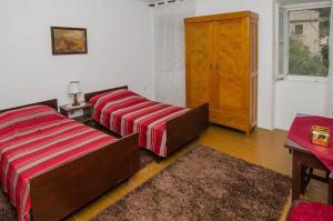 a bedroom with two beds and a table and a window at Seaside holiday house Trstenik, Peljesac - 16309 in Trstenik