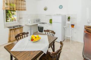 a kitchen with a table with a bowl of fruit on it at Seaside holiday house Trstenik, Peljesac - 16309 in Trstenik