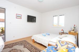 a living room with two beds and a tv at Apartments by the sea Slatine, Ciovo - 16341 in Slatine
