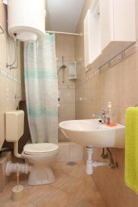 a bathroom with a white toilet and a sink at Apartments by the sea Slatine, Ciovo - 16341 in Slatine +34 photos