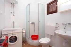 a bathroom with a washing machine and a sink at Apartments by the sea Slatine, Ciovo - 16345 in Slatine +25 photos