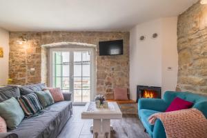 uma sala de estar com um sofá e uma lareira em Family friendly house with a swimming pool Cerion, Central Istria - Sredisnja Istra - 16332 em Visnjan
