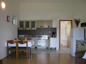 a kitchen with a table and a white refrigerator at Apartments with a parking space Palit, Rab - 16356 in Mundanije