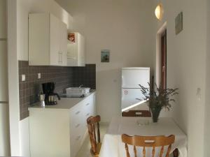 a kitchen with a table and a white refrigerator at Apartments with parking space Palit, Rab - 16356 in Mundanije