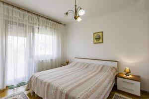 biała sypialnia z łóżkiem i oknem w obiekcie Apartments with a parking space Umag - 16354 w mieście Umag