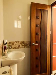 een badkamer met een wastafel en een houten deur bij Beach getaway Studio Villa in Lobo in Lobo