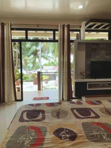sala de estar con TV y alfombra grande en Beach getaway Studio Villa in Lobo, en Lobo