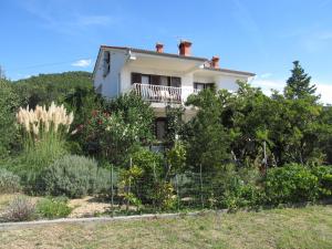 a white house on a hill with plants at Apartments with parking space Banjol, Rab - 16334 in Rab