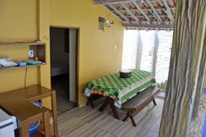 a room with a table and a bench in a room at Pousada Maracajaú in Maracajaú