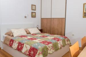 um quarto com uma cama com uma colcha em Apartments with a parking space Novi Vinodolski - 16360 em Novi Vinodolski