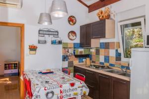 uma cozinha com uma mesa e um lavatório em Apartments with a parking space Novi Vinodolski - 16360 em Novi Vinodolski