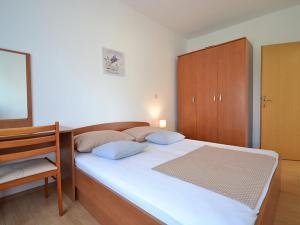 1 dormitorio con 1 cama y armario de madera en Holiday house with a parking space Sukosan, Zadar - 16398, en Sukošan