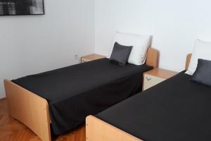 two beds sitting next to each other in a room at Apartments by the sea Zadar - Diklo, Zadar - 16419 in Zadar