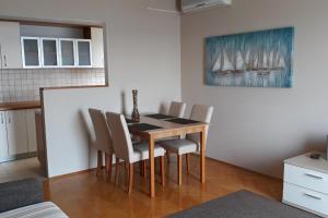 a dining room table and chairs in a room at Apartments by the sea Zadar - Diklo, Zadar - 16419 in Zadar