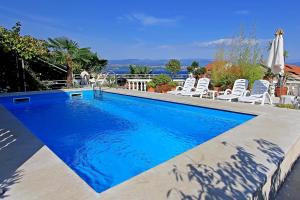 a large swimming pool with chairs at Family friendly apartments with a swimming pool Lovran, Opatija - 14178 in Lovran