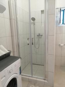 a shower in a bathroom with a washing machine at Holiday house with a swimming pool Rogac, Solta - 16444 in Grohote