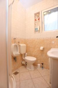 ein Badezimmer mit WC, Urinal und Waschbecken in der Unterkunft Apartments by the sea Podgora, Makarska - 16476 in Podgora