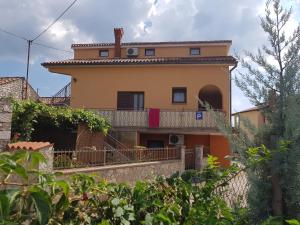 a house with a balcony in front of it at Apartments with a parking space Tar, Porec - 16475 in Tar