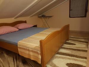 a bedroom with a wooden bed with pink pillows at Apartments with a parking space Tar, Porec - 16475 in Tar