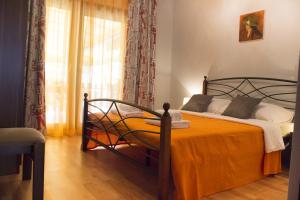 sypialnia z łóżkiem z pomarańczowym kocem w obiekcie Apartments with a parking space Sutomiscica, Ugljan - 16524 w mieście Preko