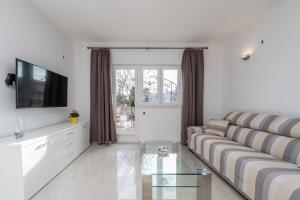 ein Wohnzimmer mit einem Sofa und einem TV in der Unterkunft Holiday house with a parking space Vrsi - Mulo, Zadar - 16527 in Vrsi
