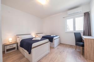 a bedroom with two beds and a desk and a window at Holiday house with a parking space Vrsi - Mulo, Zadar - 16527 in Vrsi
