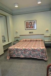 a hotel room with a bed and a picture on the wall at Le Petit Hotel in Turin