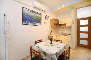 a kitchen with a table and chairs in a room at Apartment Mali Iz 16535b in Veli Iž +11 photos