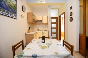 a dining room with a table with wine glasses on it at Apartment Mali Iz 16535b in Veli Iž