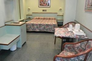 a room with two beds and a table and chairs at Le Petit Hotel in Turin