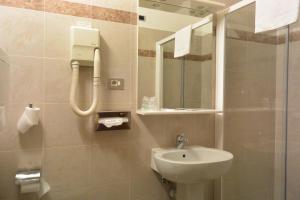 a bathroom with a sink and a shower with a mirror at Le Petit Hotel in Turin