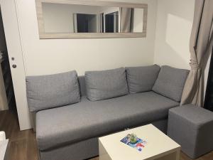 Sala de estar con sofá gris y espejo en Apartment Pakostane 16579a en Pakoštane
