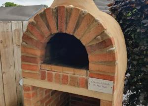 a brick pizza oven with a sign on it at Durham Coastal Lodges in Haswell