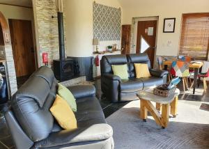 sala de estar con 2 sillas de cuero y mesa en Durham Coastal Lodges, en Haswell