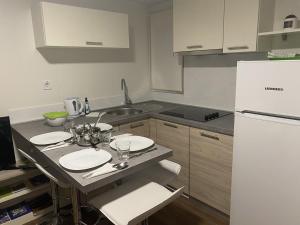 eine Küche mit einem Tisch und einem weißen Kühlschrank in der Unterkunft Apartments with a parking space Pakostane, Biograd - 16579 in Pakoštane