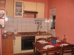 a kitchen with a table and a sink and a stove at Apartment Sucuraj 16404b in Sućuraj +14 photos