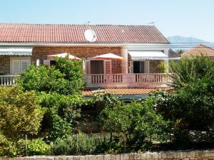 a house with a porch and a balcony at Apartments by the sea Sucuraj, Hvar - 16404 in Sućuraj