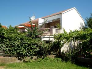 une maison avec un balcon et une clôture dans l'établissement Apartments by the sea Sucuraj, Hvar - 16404, à Sućuraj