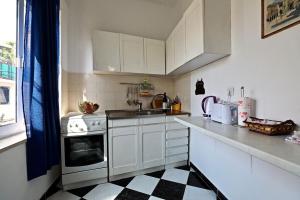 a kitchen with white cabinets and a black and white checkered floor at Apartments by the sea Sucuraj, Hvar - 16404 in Sućuraj +24 photos