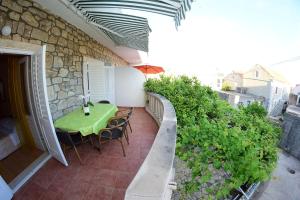 d'une terrasse avec une table et des chaises vertes sur un balcon. dans l'établissement Apartments by the sea Sucuraj, Hvar - 16404, à Sućuraj