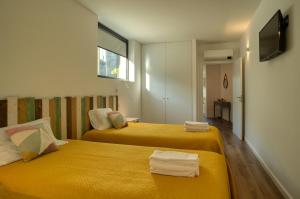 two beds in a small room with yellow sheets at Varanda de Sistelo in Sistelo