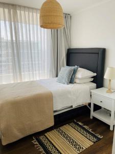 1 dormitorio con 1 cama y ventana grande en Alta Vista Las Condes en Santiago