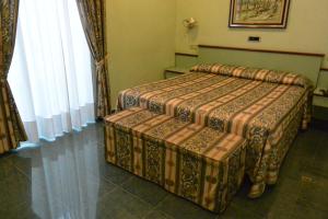 two beds in a hotel room with curtains at Le Petit Hotel in Turin
