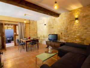a living room with a couch and a table at Gîte chaleureux à Daglan avec terrasse et parking - FR-1-616-275 in Daglan