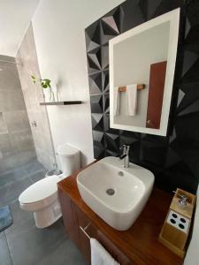 オアハカにあるIluminada y confortable habitaciones en Casa Margarita Oaxacaのバスルーム(白い洗面台、トイレ付)