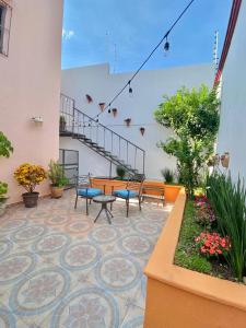un patio con bancos y una escalera en un edificio en Iluminada y confortable habitaciones en Casa Margarita Oaxaca en Oaxaca de Juárez