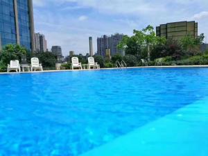 a large swimming pool with chairs in a city at Changsha Jiaxing Inn in Changsha