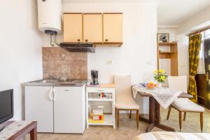 莫托文的住宿－Apartments with a parking space Motovun, Central Istria - Sredisnja Istra - 14160，厨房配有小桌子和白色冰箱。
